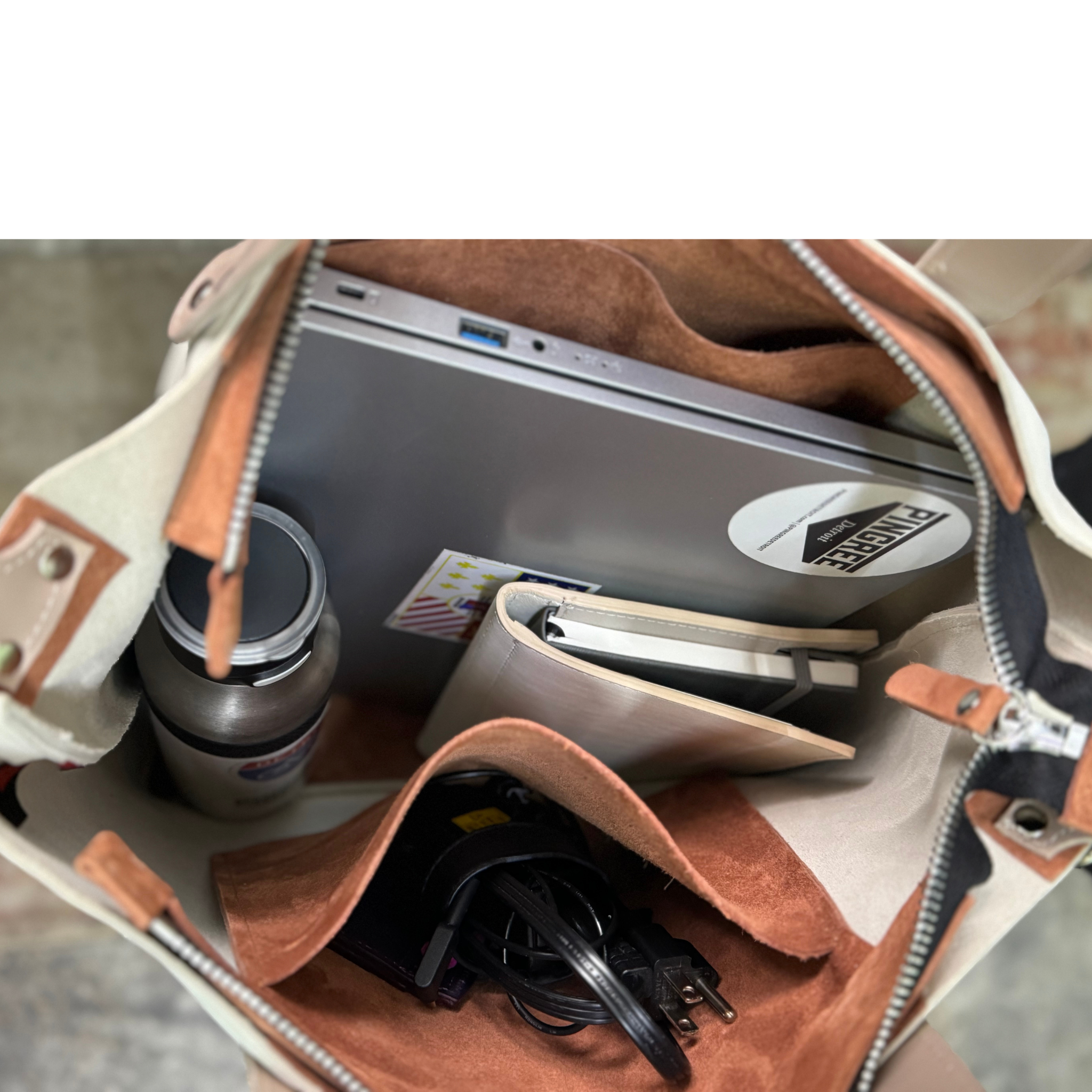 Cappuccino color leather bag with suede inside. This travel tote or work bag with a zipper and made sustainably by Pingree Detroit,
In Detroit, with upcycled leather, pictured here with the adjustable seat belt crossbody strap. Made for travel or weekender bag. Carry-on compliant.