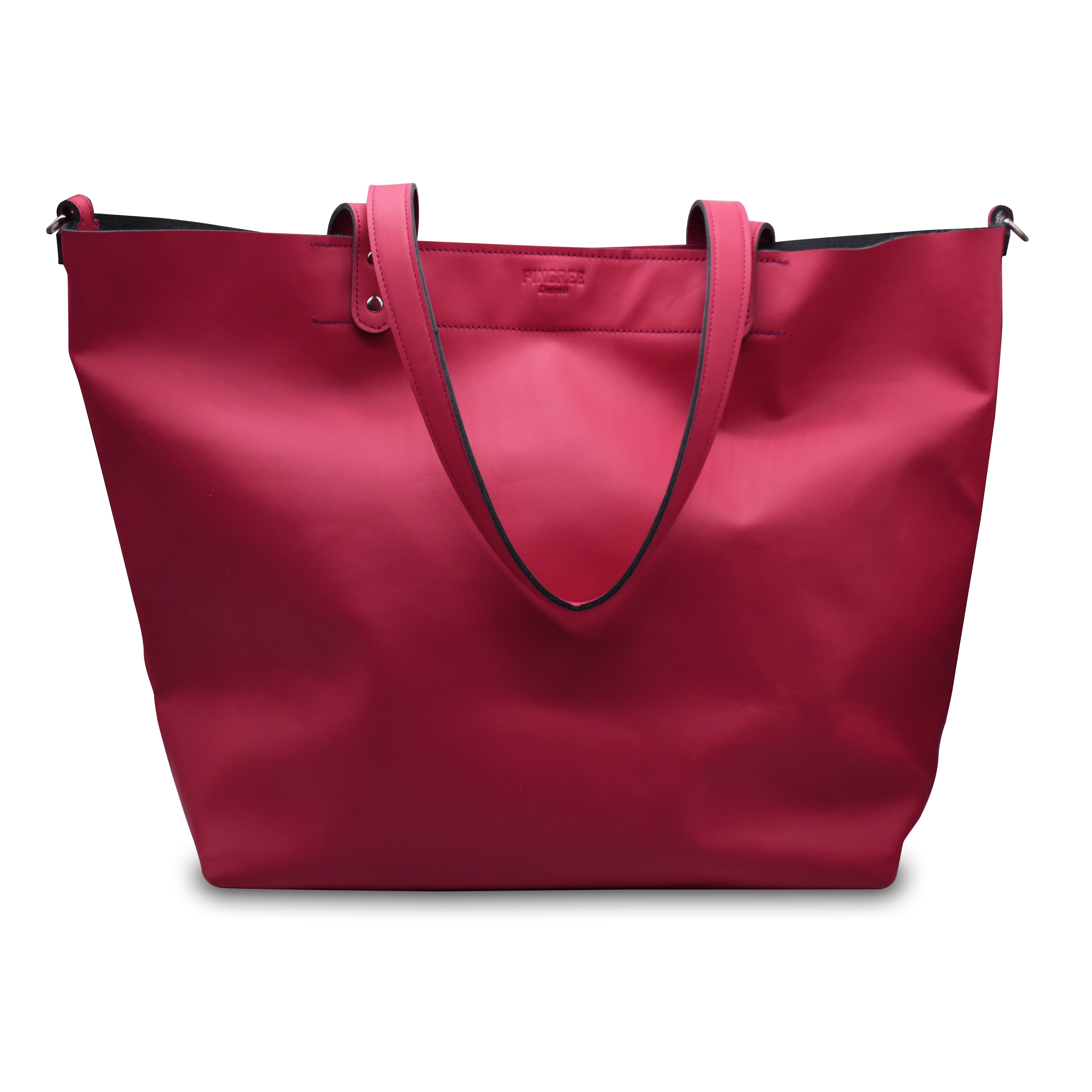 Hot pink shopper tote bag with black accents on a white background. Made in Detroit. Leather bag crafted from upcycled automotive leather. Crossbody strap available.