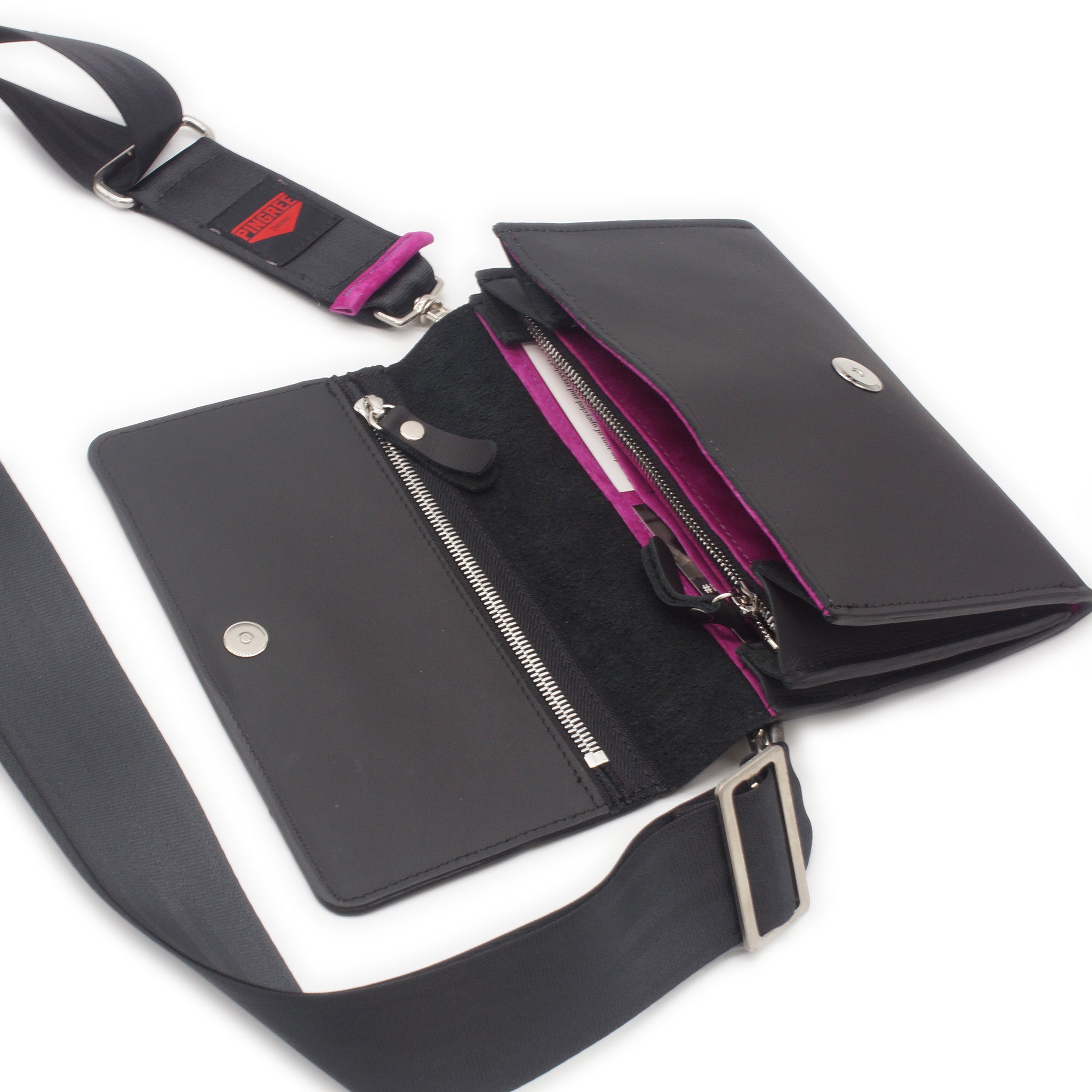 The Adeline Lux, pictured here open with seatbelt straps, a funky jam, fuchsia suede interior, and exterior all black leather, upcycled from the automotive industry, with clean rounded corners, magnetic closure, and a wristlet. This 5-in-1 bag is handmade in Detroit, MI USA, with upcycled leather from the automotive industry. Each comes with a picture of the Veteran or Detroiter who made it.