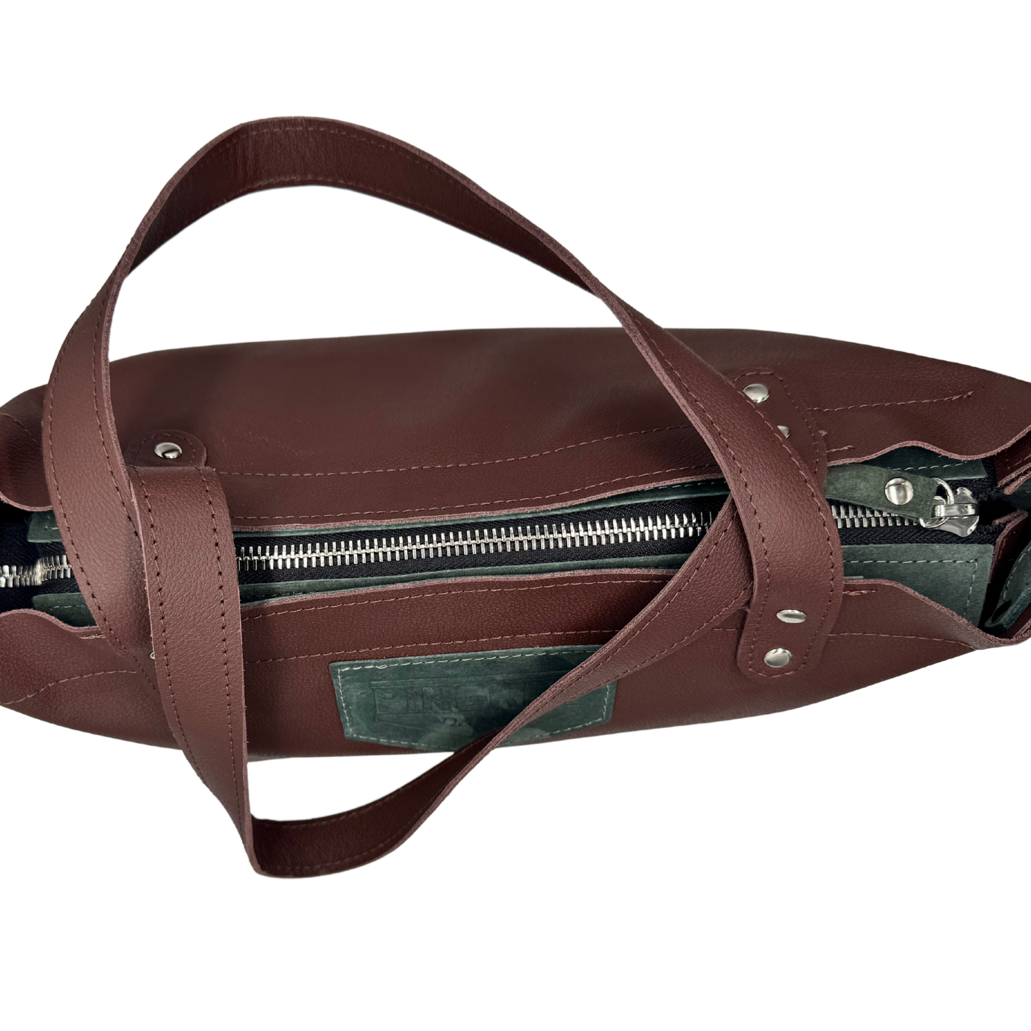 Top view of the zipper closure on the M1 compact Leather Work & Travel zipper Tote in hearth and sage. Handmade in Detroit with leather up cycled from the Automotive industry with American Made hardware a zipper closure a detachable Crossbody strap included feet on the bottom and grateful for work or travel. Carry-on compliant.