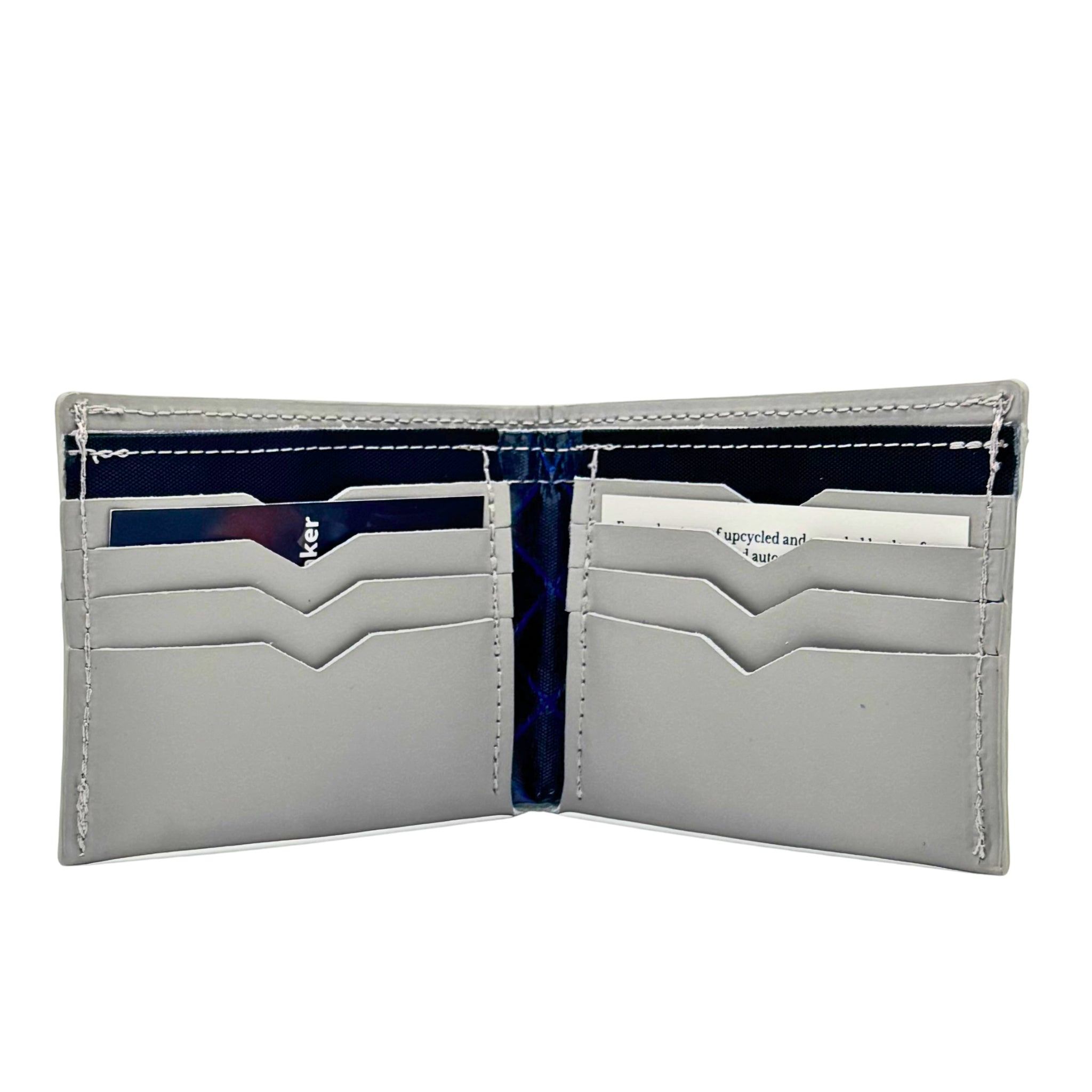 Grey with ripstock black accent billfold wallet, pictured here open. Made in Detroit, Michigan USA. Big enough for George Costanza, 10 pockets, leather upcycled from the production of new cars, handmade in Detroit by U.S. Veterans and Detroiters. Liner made from upcycled material from the production of Army tents.