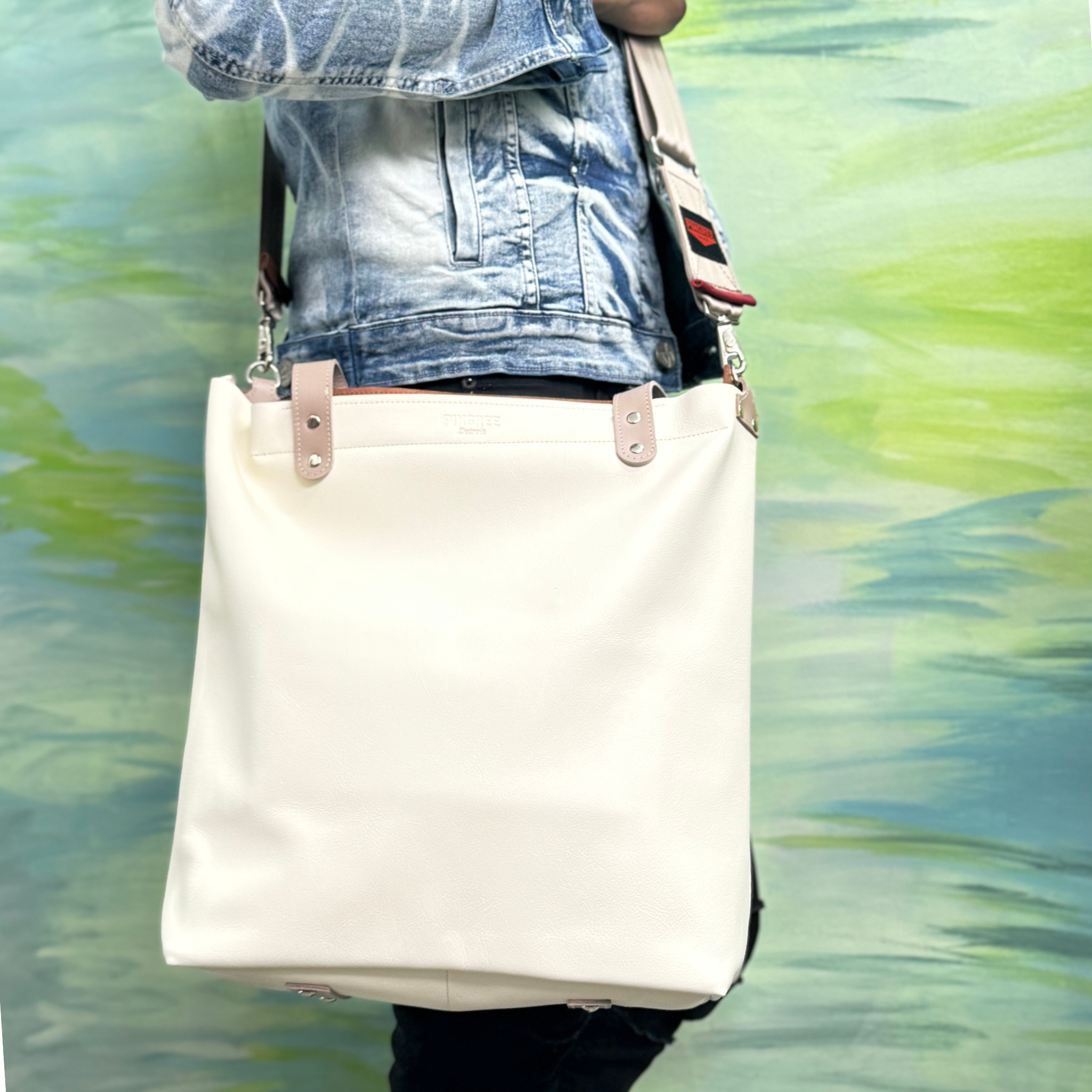 Cappuccino color leather bag and travel tote or work bag with a zipper and made sustainably by Pingree Detroit,
In Detroit, with upcycled leather, pictured here with the adjustable seat belt crossbody strap. Made for travel or weekender bag. Carry-on compliant.