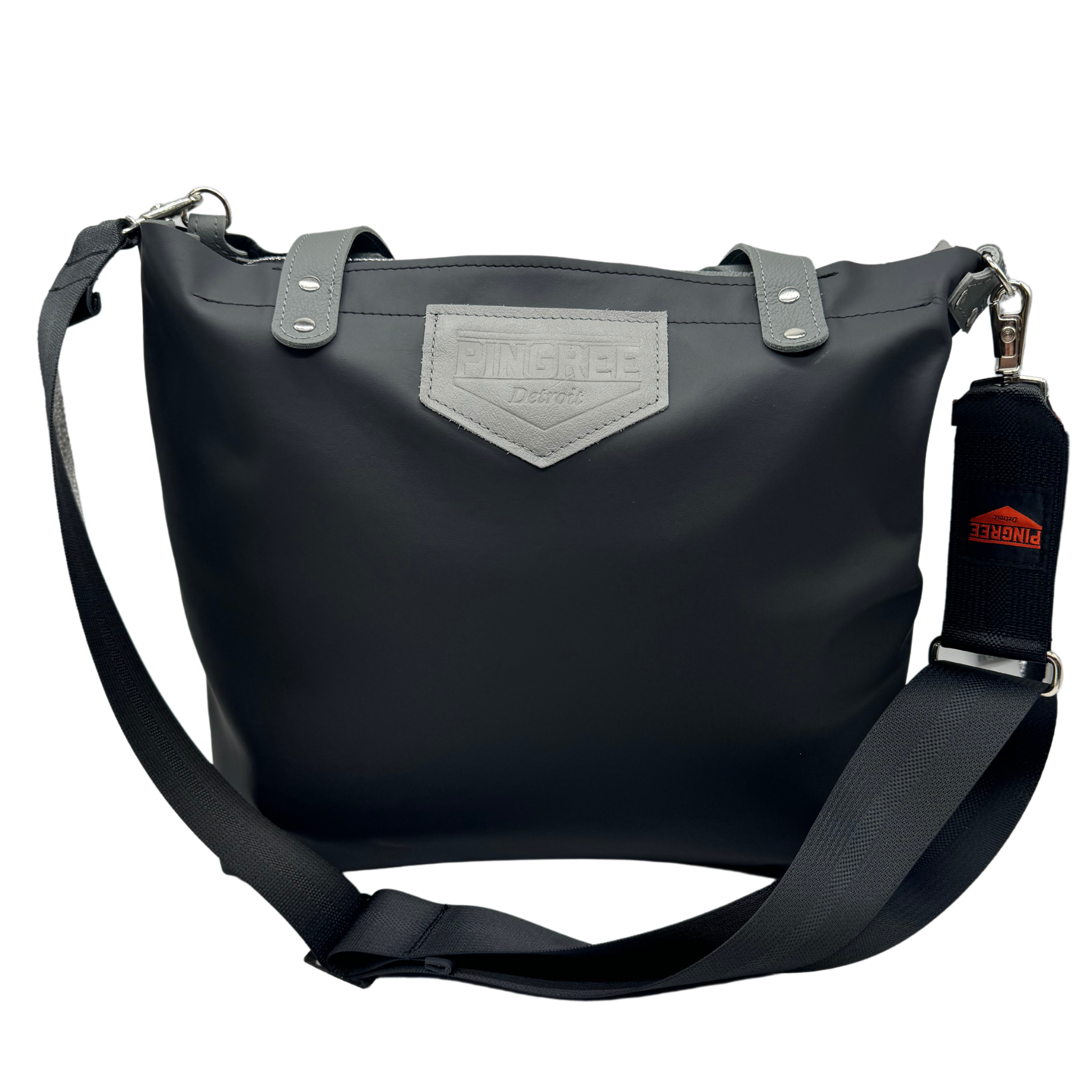 M1 Leather Work & Travel zipper Tote in black. Handmade in Detroit with leather up cycled from the Automotive industry with American Made hardware a zipper closure a detachable Crossbody strap included feet on the bottom and grateful for work or travel. Carry-on compliant.