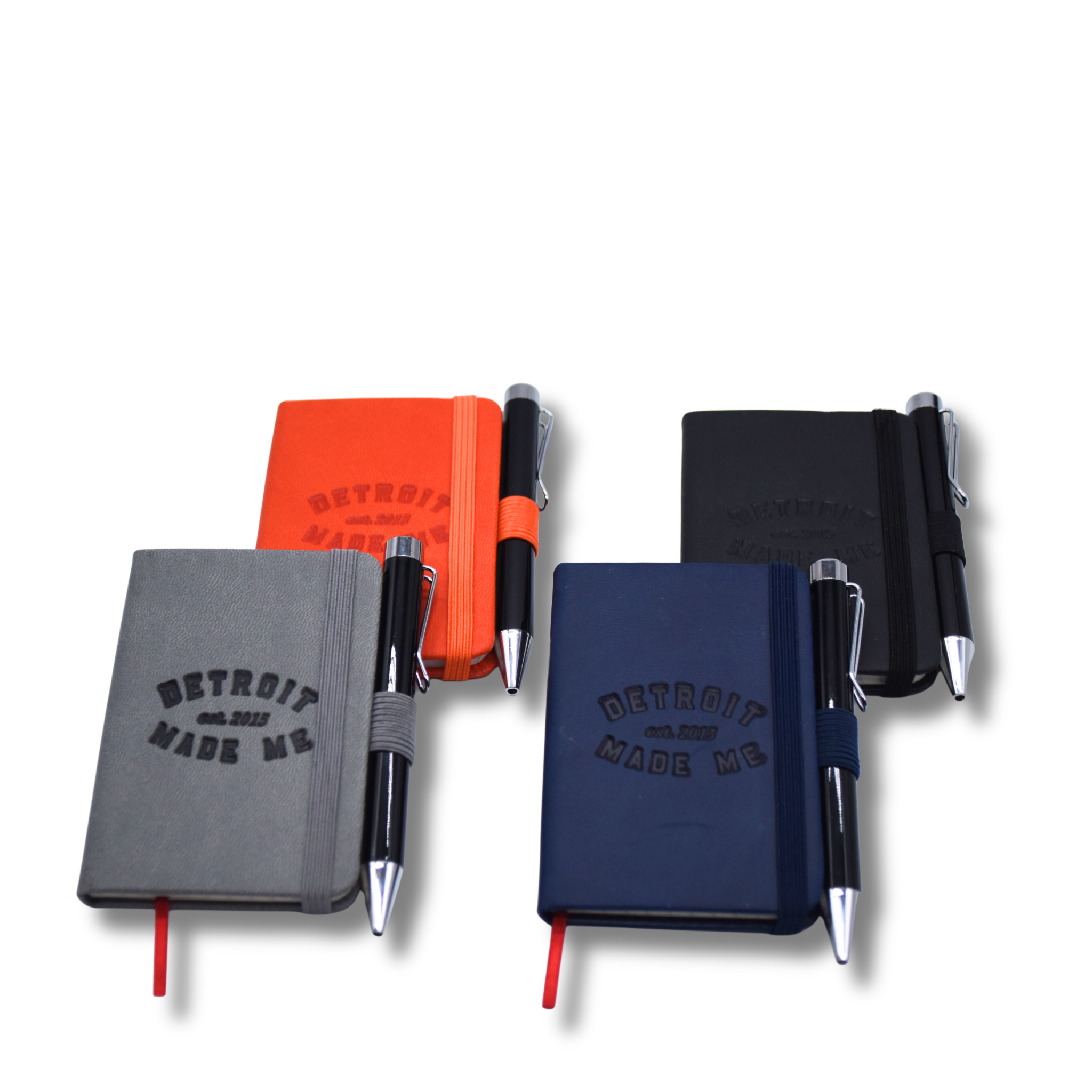 Four notebooks with pens on a white background, featuring 'Detroit Made Me' text. Pocket size. Mini journals the size if a business card.