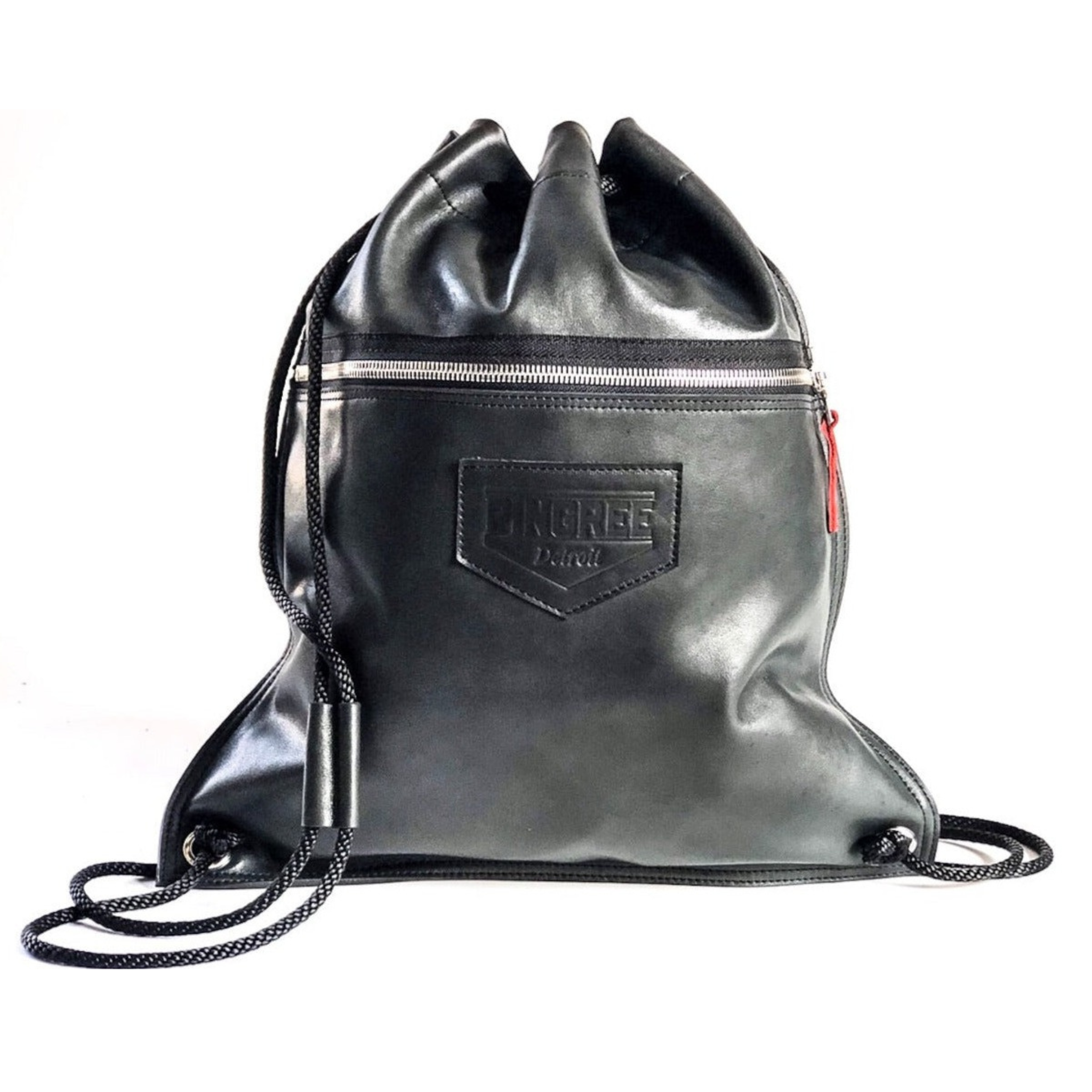 A leather drawstring bag handmade in Detroit with buttery soft leather upcydled from the production of brand new cars in the Motor City. Crafted with american made zippers, and comes with tow zipper pockets and the name of the Veteran or Detroiter who made your Detroit Drawstring bag.