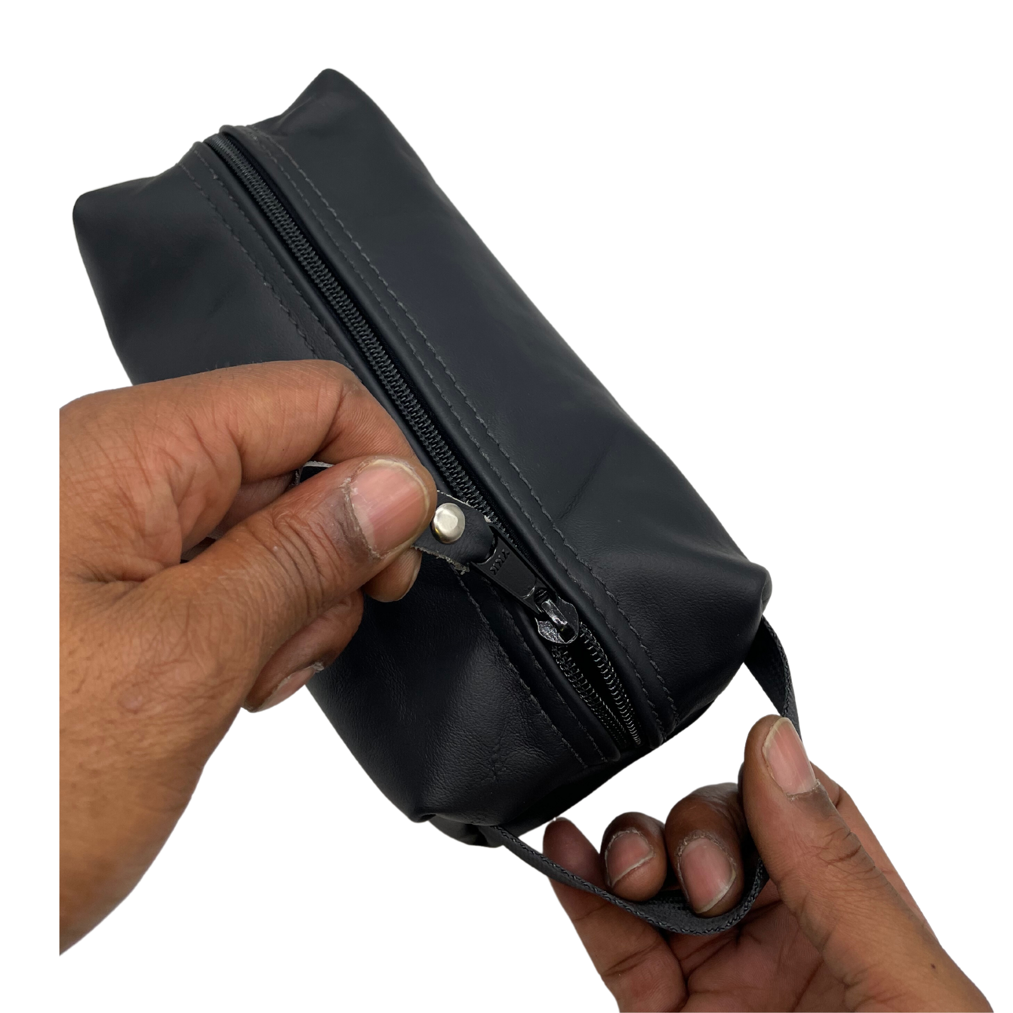 A close-up image of a person's hand opening a black Detroit Dopp Kit, revealing the interior with a zipper.