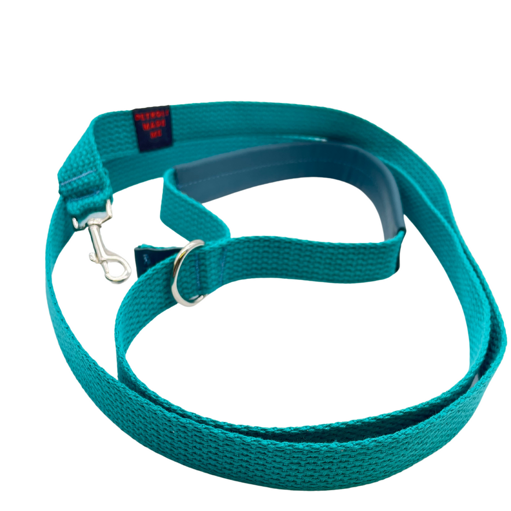 A teal dog leash with 100% organic cotton industrial webbing, a soft upcycled automotive leather handle, and metal hardware, designed and made in Detroit.