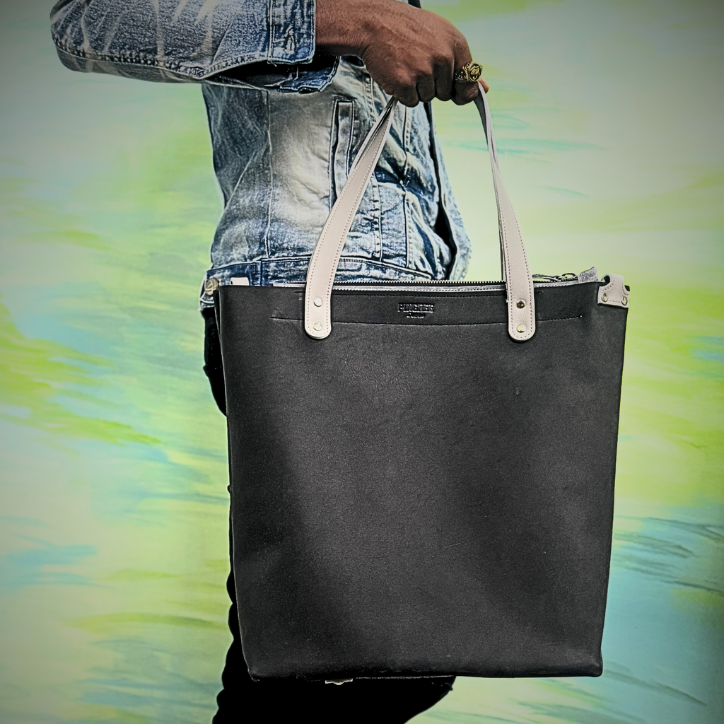 Onyx black leather bag and travel tote or work bag with a zipper and made sustainably by Pingree Detroit,
In Detroit, with upcycled leather, pictured here without the seat belt crossbody strap. Made for travel or weekender bag. 