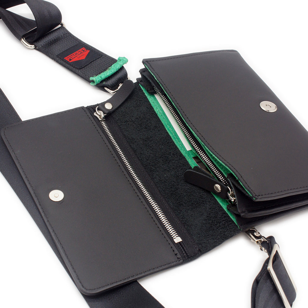 The Adeline Lux, pictured here open with seatbelt straps, a Shamrock Green interior, and exterior all black leather, upcycled from the automotive industry, with clean rounded corners, magnetic closure, and a wristlet. This 5-in-1 bag is handmade in Detroit, MI USA, with upcycled leather from the automotive industry. Each comes with a picture of the Veteran or Detroiter who made it. 