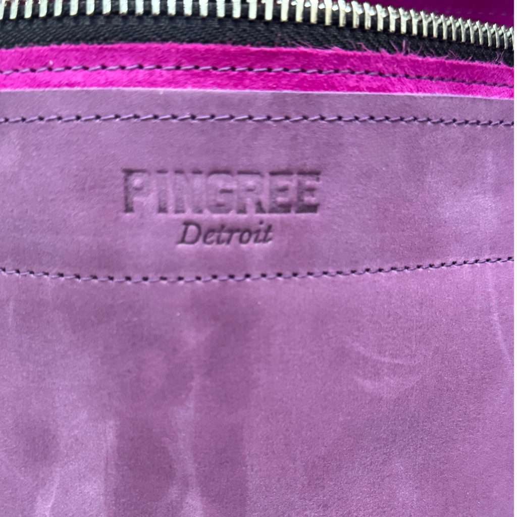 Purple leather bag and travel tote or work bag with a zipper and made sustainably by Pingree Detroit,
In Detroit, with upcycled leather, pictured here is the logo that is embossed 