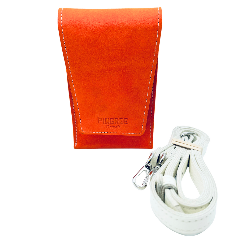 The Motown venue bag, a pouch sized to get into any sports, stadium, concert venue, and performance hall. Pictured here in tiger lily orange with leather strap option. 4” x 6” x 1.5” Handmade by Veterans and DETROITERS with Upcycled leather from the auto industry. Available with a leather strap or a seatbelt strap.