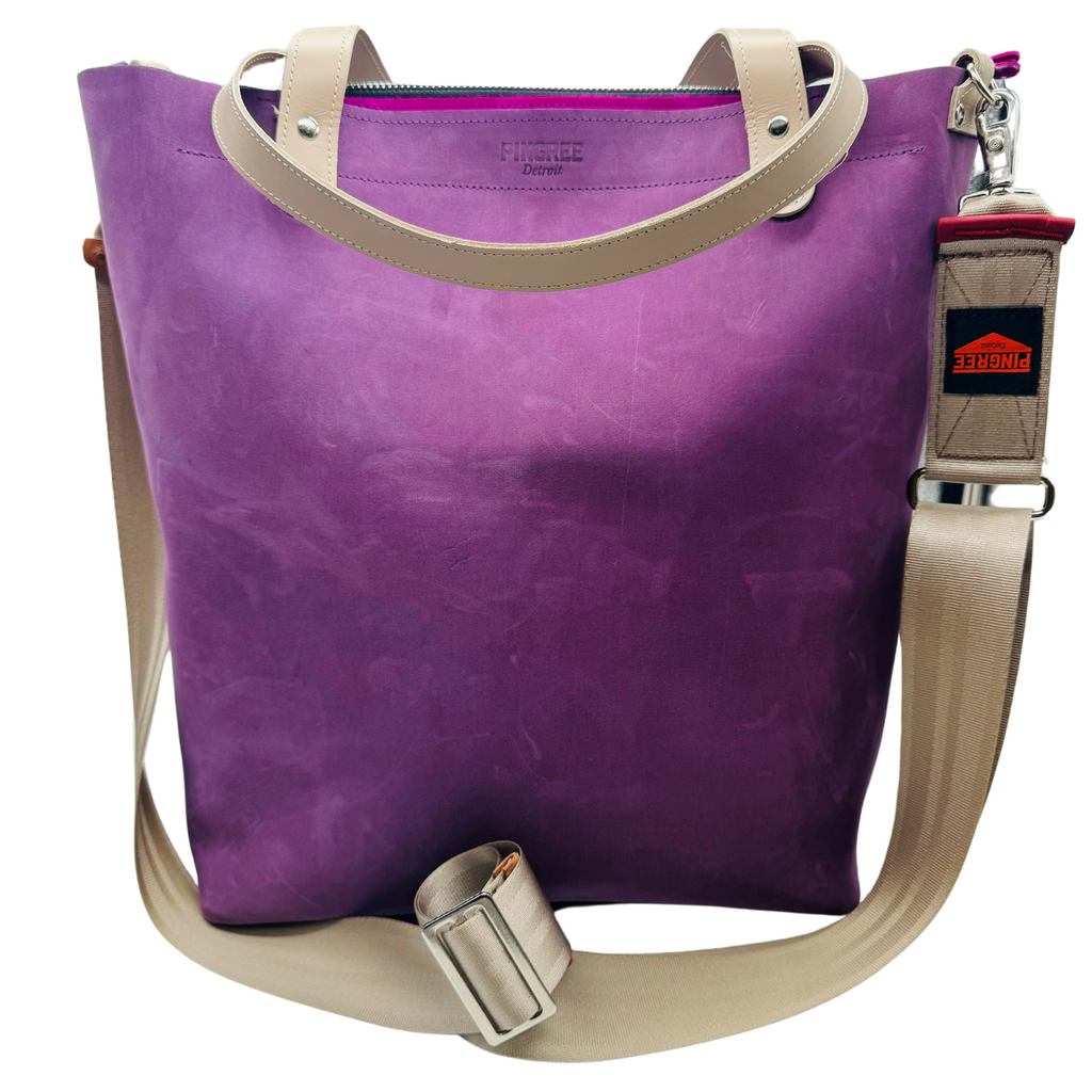 Purple leather bag and travel tote or work bag with a zipper and made sustainably by Pingree Detroit,
In Detroit, with upcycled leather, pictured here with the seat belt crossbody strap