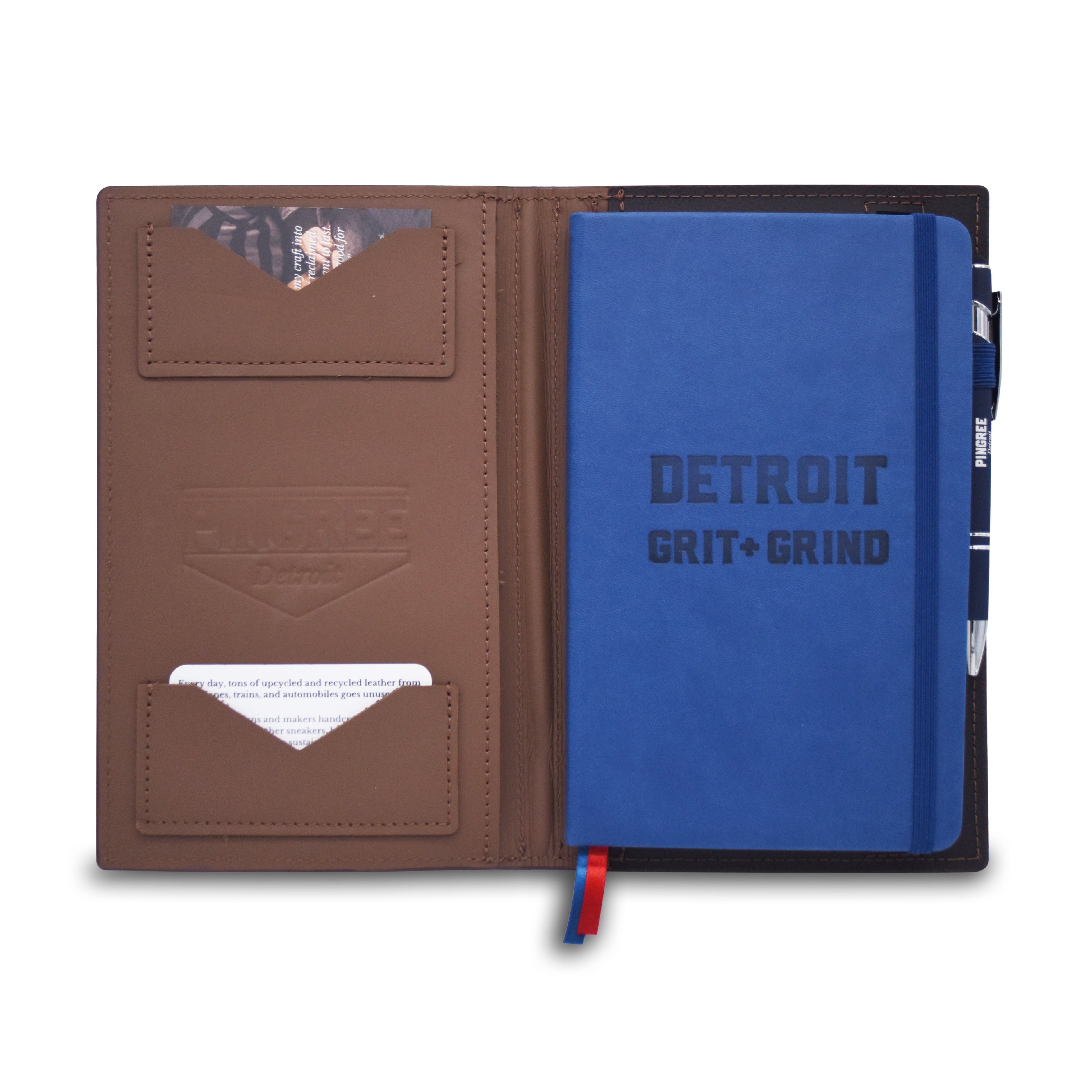 A brown leather notebook cover shown open on a white background, containing a blue hardcover notebook with 'DETROIT GRIT + GRIND' printed on the cover, card slots, and a pen loop.