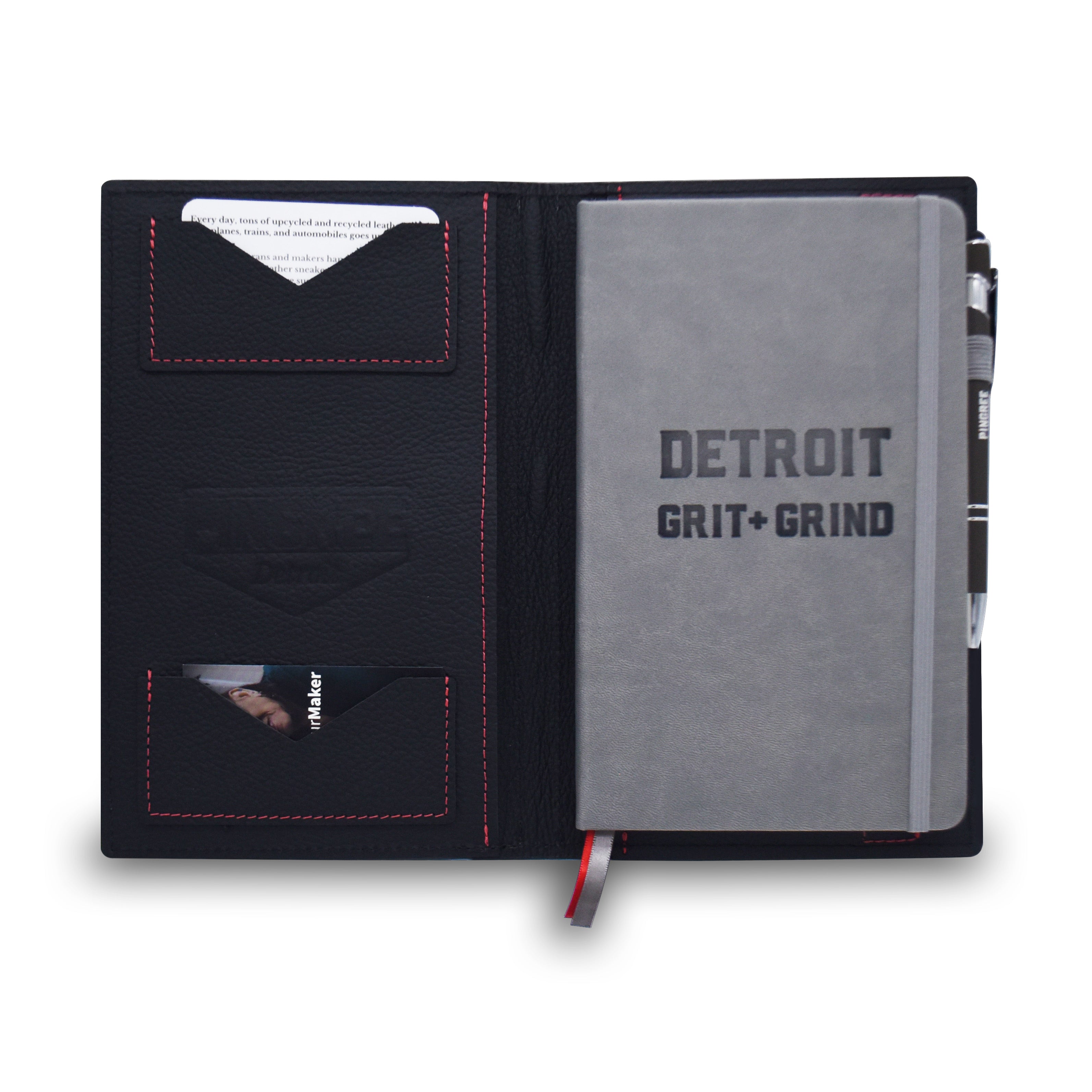 A black leather notebook cover with red stitching, shown open on a white background. The cover contains card slots, a gray notebook with 'DETROIT GRIT + GRIND' printed on the cover, and a black pen.