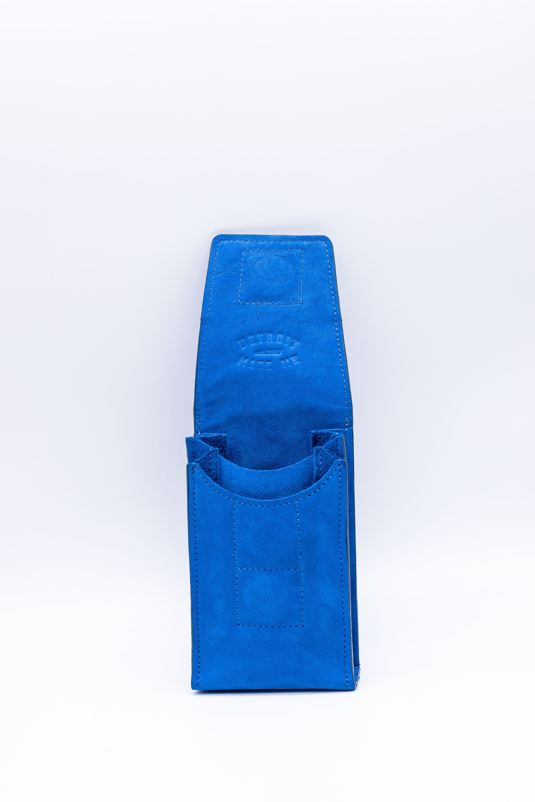 Blue on  inside and edges. A stadium bag that can be worn on a belt or as a crossbody. Carries your phone and features magnetic closure.  With leather strap on a white background. Made in Detroit with leather upcycled from the automotive industry with the Pingree logo on the front and silver hardware made in America. 