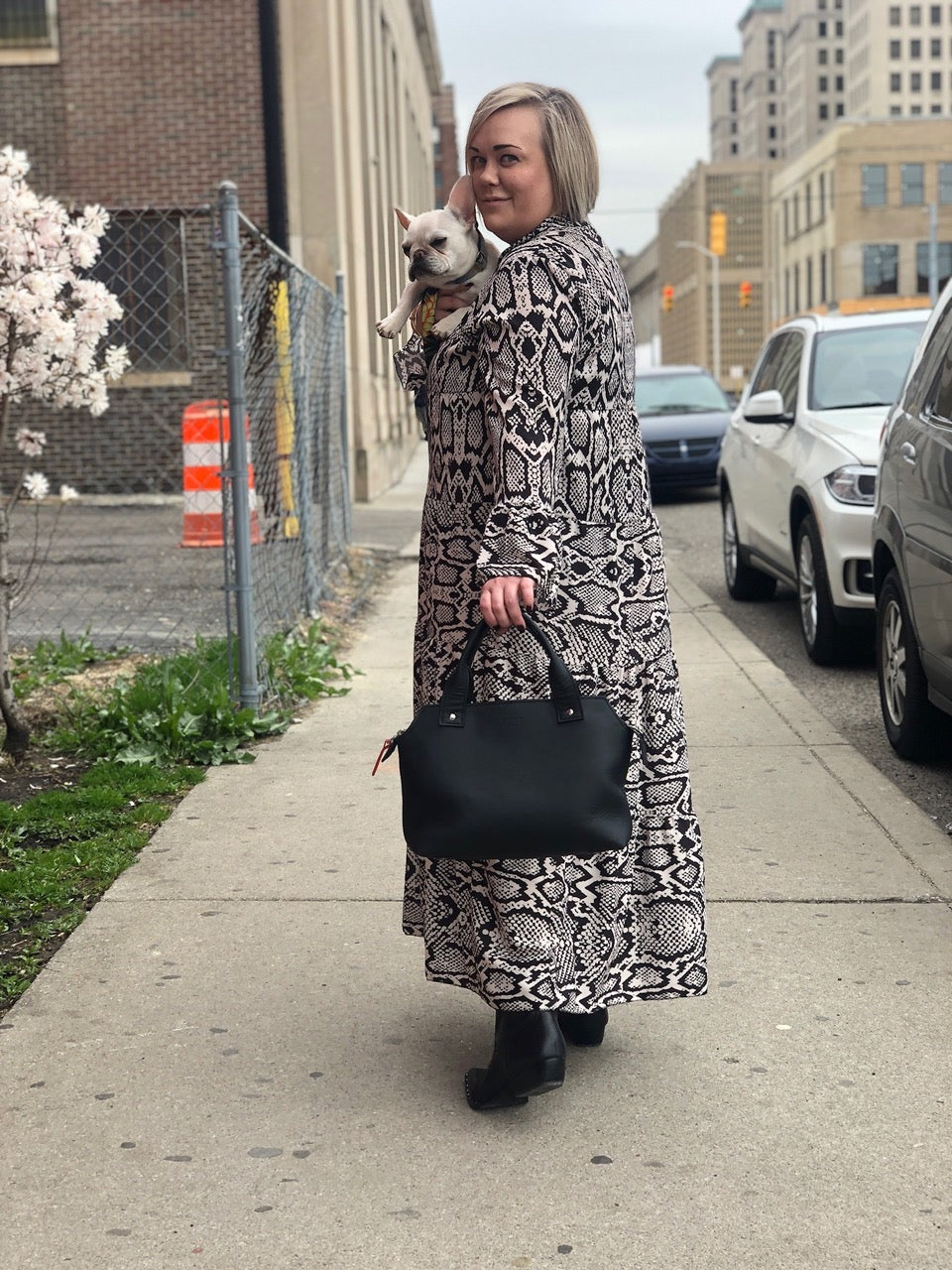Pingree's Beaubien bag in onyx on a walk in Detroit, modeled by a woman and her dog. All leather made from repurposed from the automotive industry.