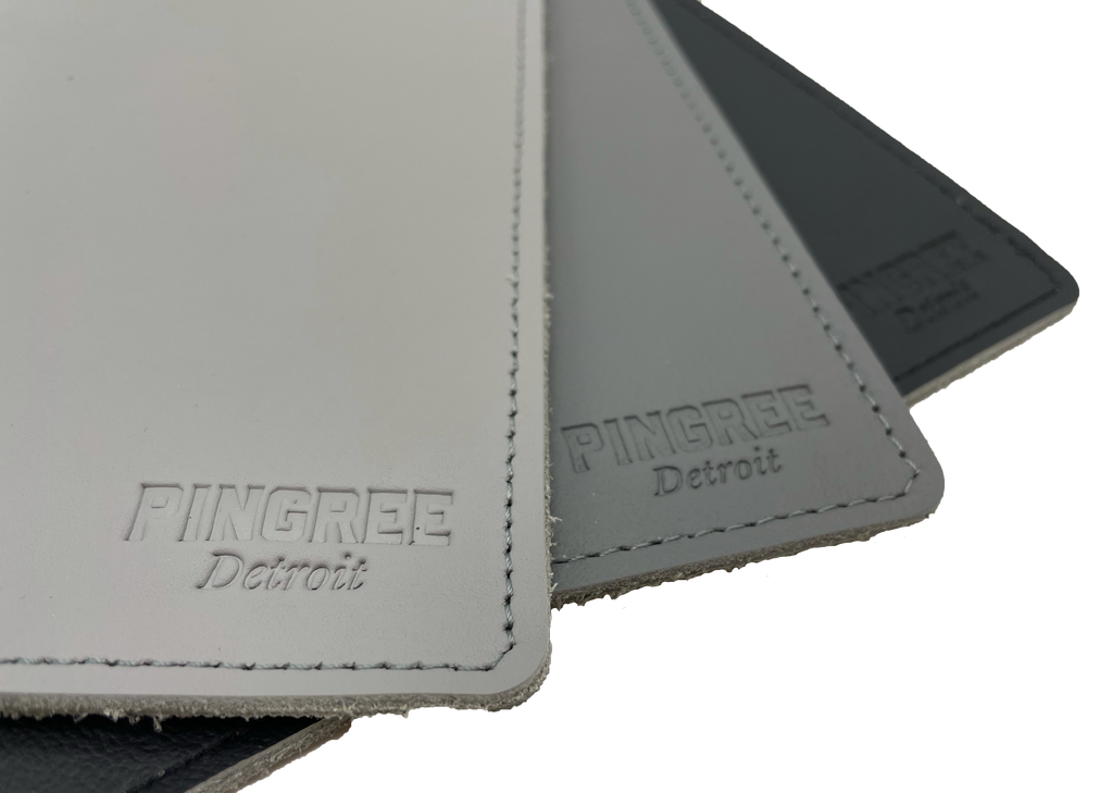 Pingree Mouse Pad in three shades of grey. Pingree logo prominently displayed on front corner of mouse pad. Made from repurposed automotive leather.