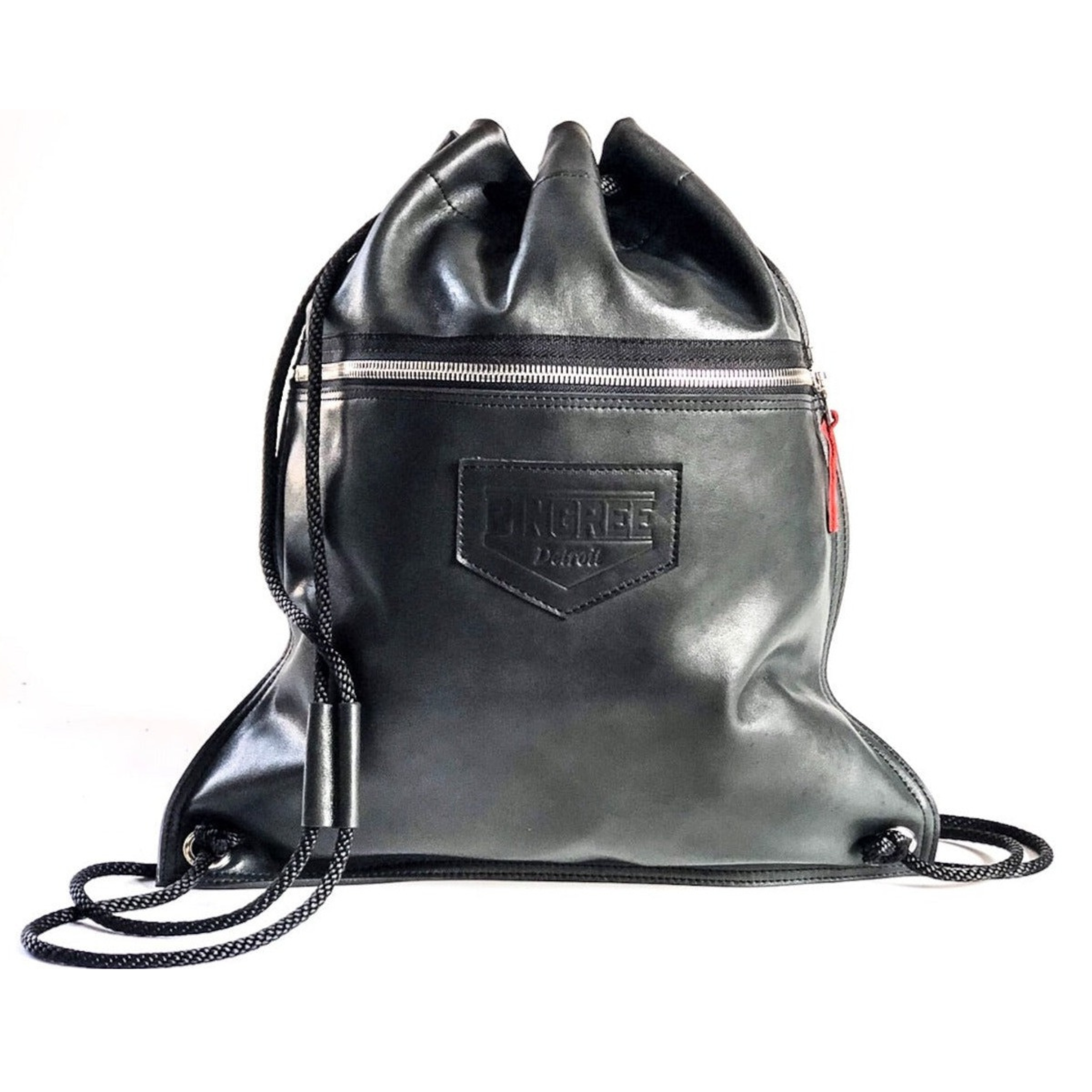 A leather drawstring bag handmade in Detroit with buttery soft leather upcydled from the production of brand new cars in the Motor City. Crafted with american made zippers, and comes with tow zipper pockets and the name of the Veteran or Detroiter who made your Detroit Drawstring bag. 