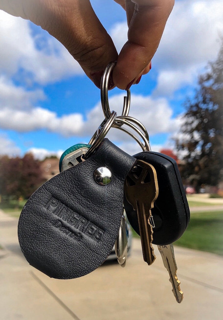 Kercheval key chain on a ring of keys with a sunny Michigan sky. All hardware made in the USA. Ecofriendly leather repurposed from waste from the automotive industry.